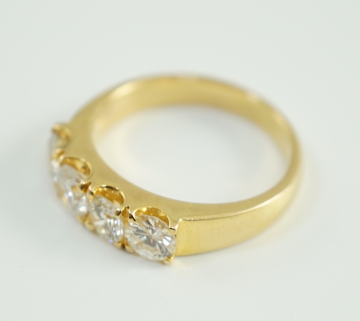 A modern 750 gold and four stone diamond set ring
